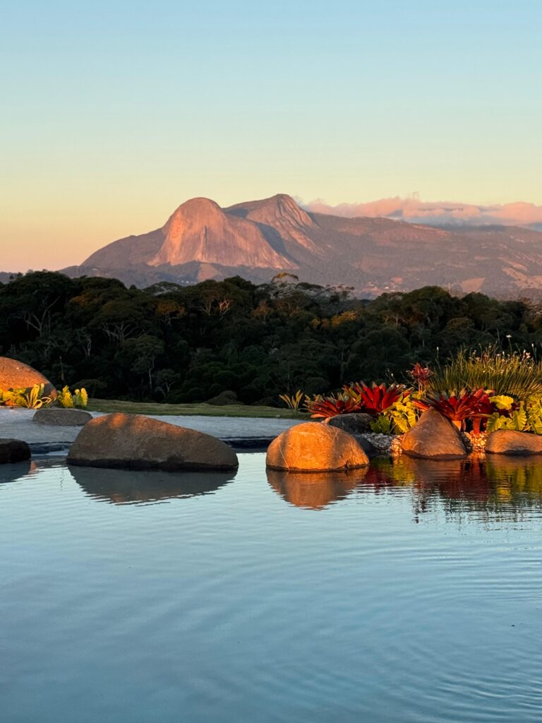 Pedra Azul refletida no lago cinematográfico do Laguna Alto Viçosa ao entardecer
