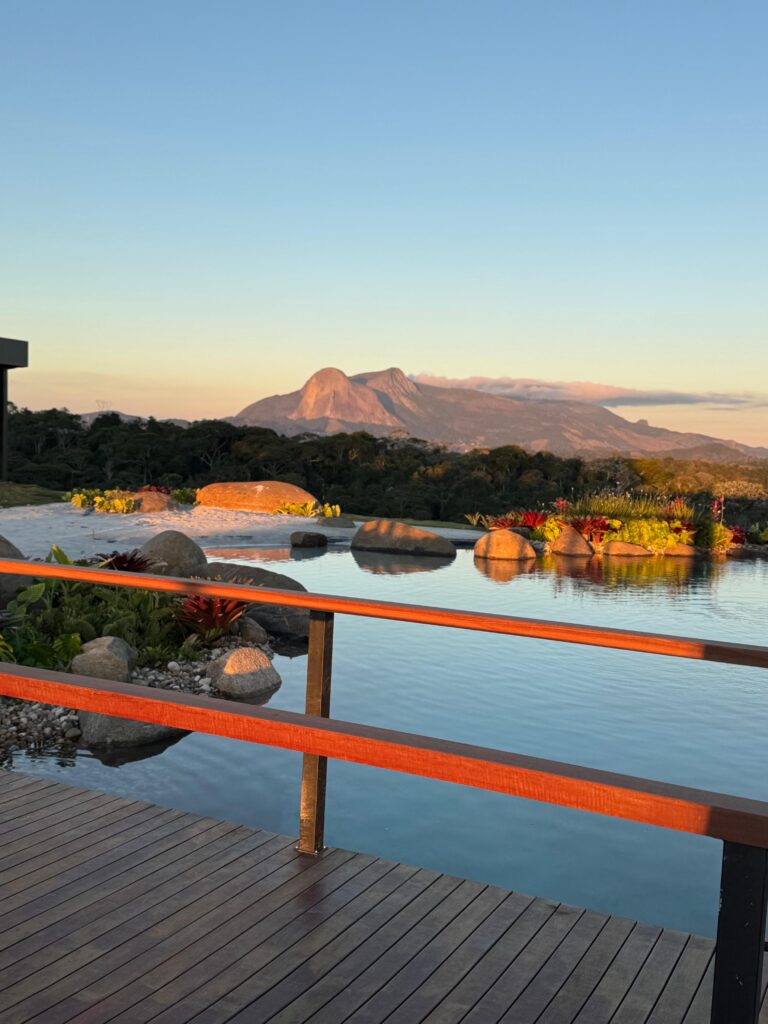 Lago cinematográfico do Laguna Alto Viçosa com vista para a Pedra Azul ao pôr do sol